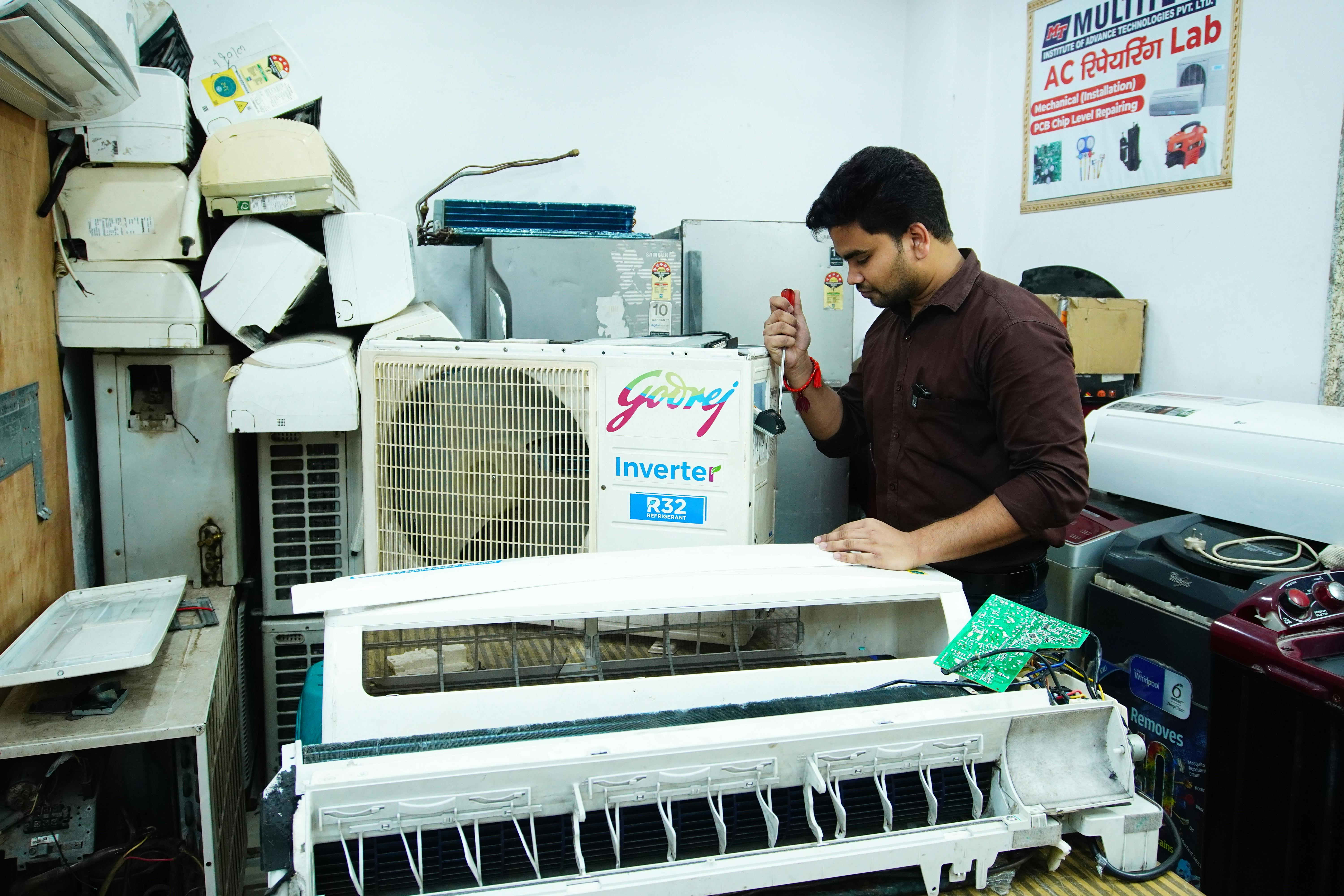 Technician repairing an AC unit in a Dubai apartment